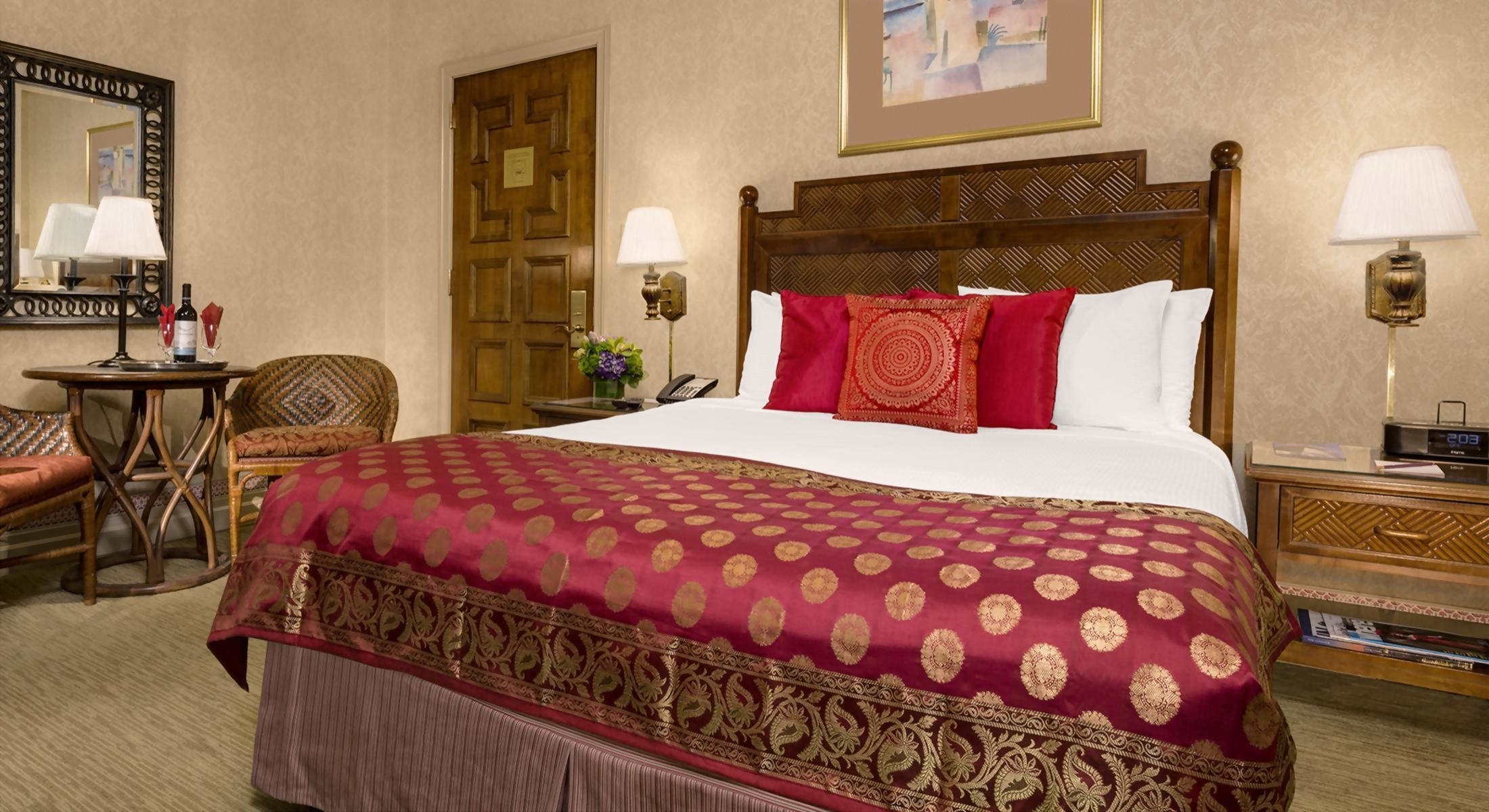A luxurious hotel room with a king-sized bed, nightstand, and lamp