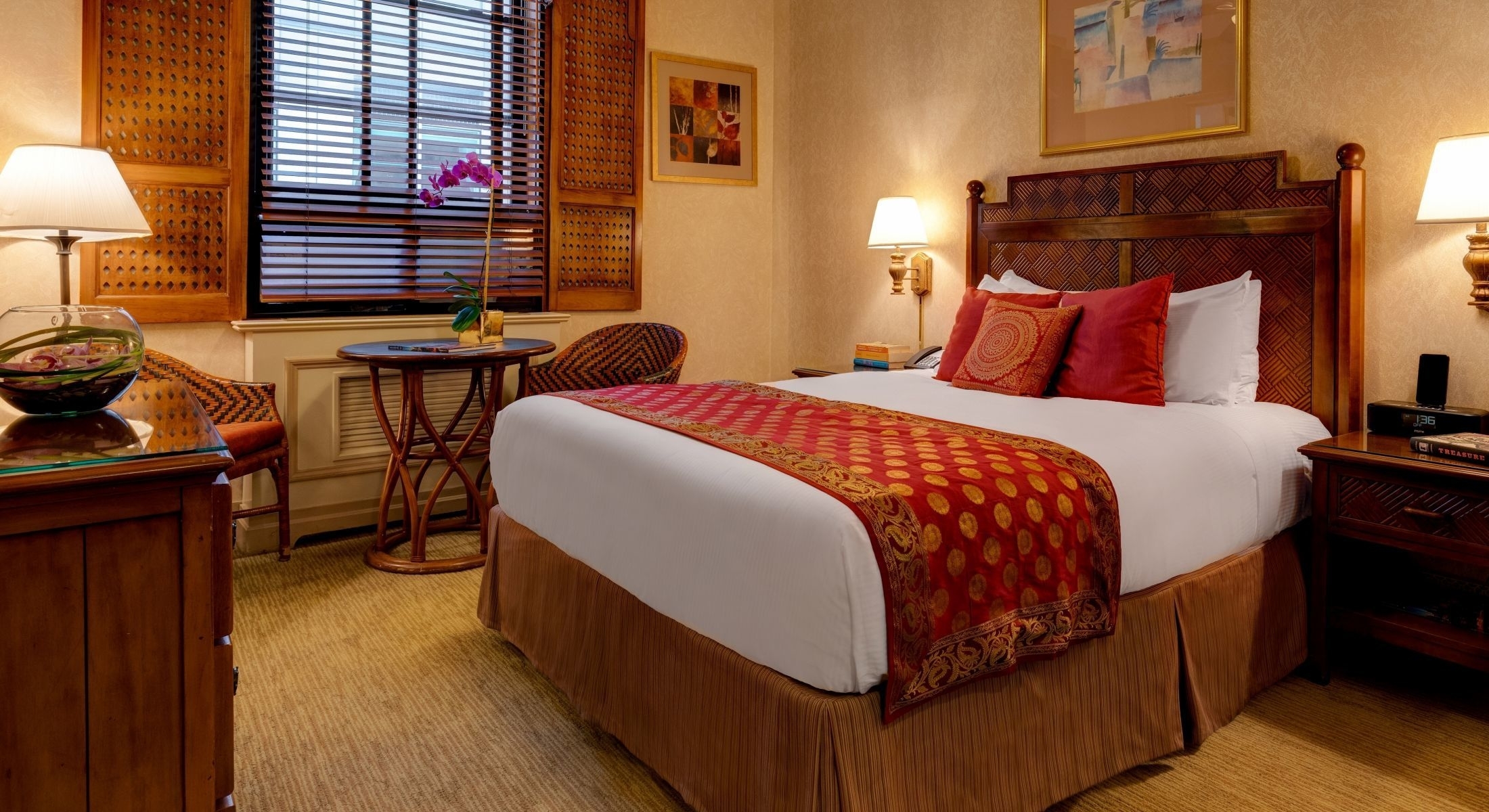 A hotel room with a large bed, nightstands, and a window